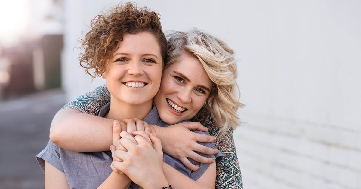 Lesbian couple hugging and smiling