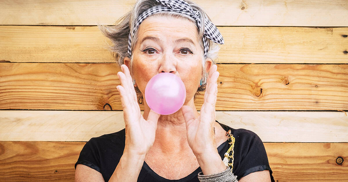 Older white woman blowing bubble gum