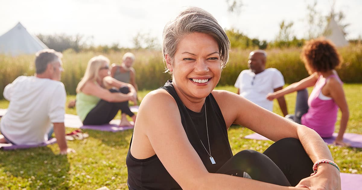 Smiling older woman sitting in a group in a park