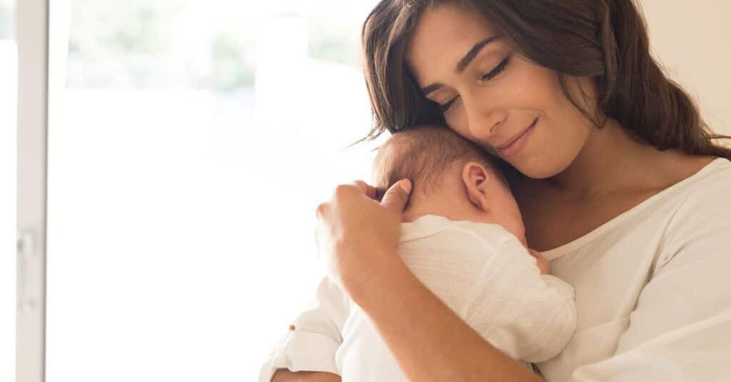 Photo of mother cradling newborn baby