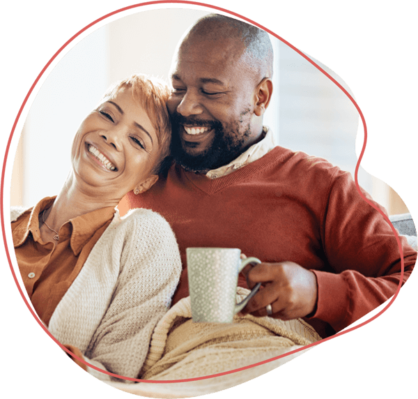 older couple on couch drinking tea and smiling