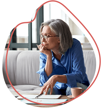 older woman sitting on sofa and researching on laptop computer